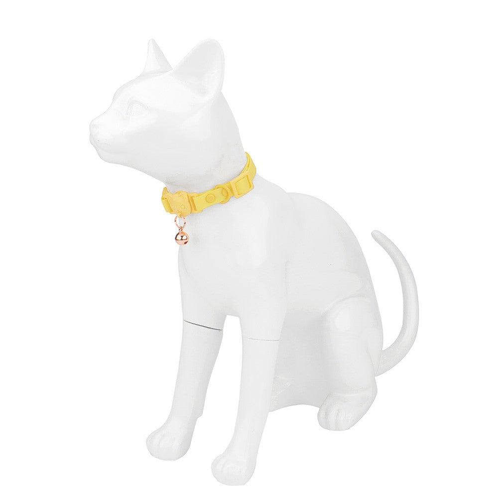 Yellow cat collar with bell on a white cat figure to show the fit