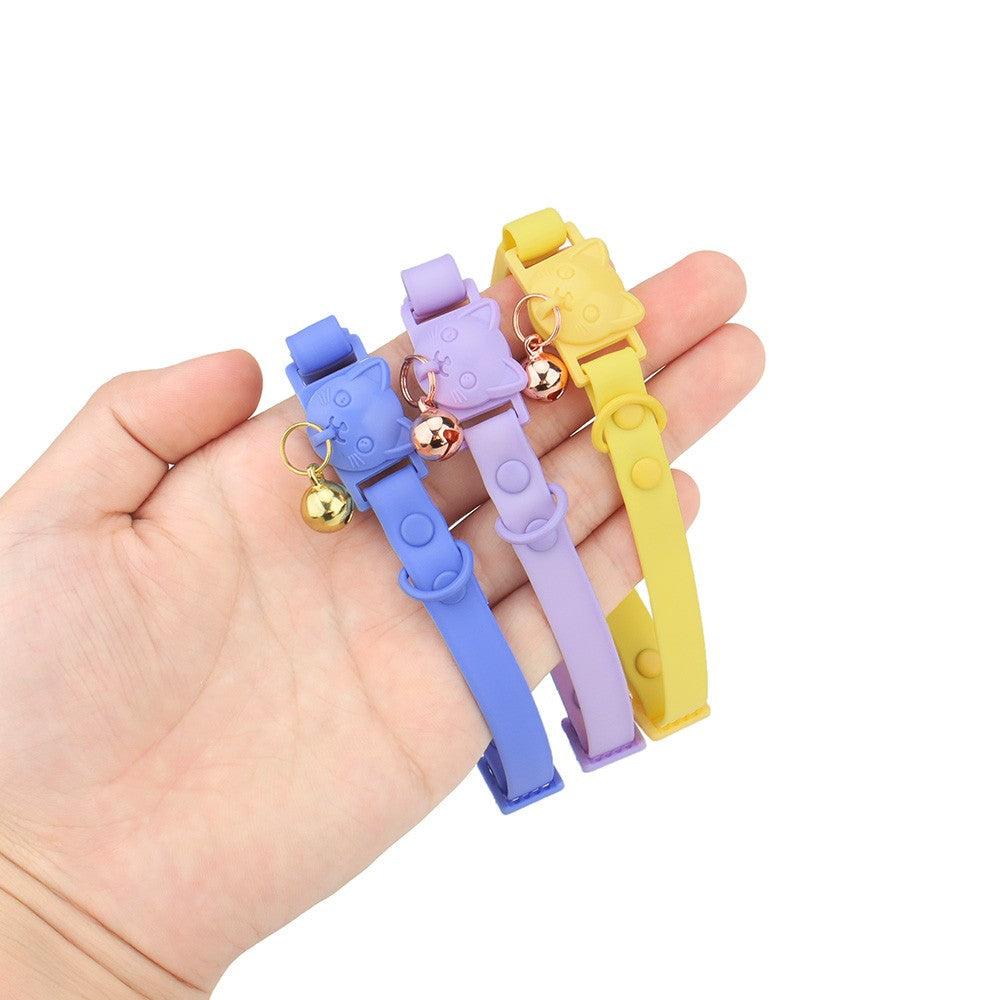 Hand holding three PVC cat collars in blue, lilac and yellow