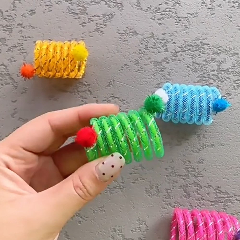 Hand holding a green cat spring toy with a red pom-pom