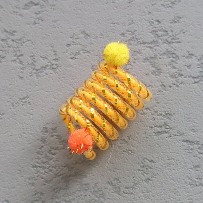 Yellow cat spring toy with orange and yellow pom-poms