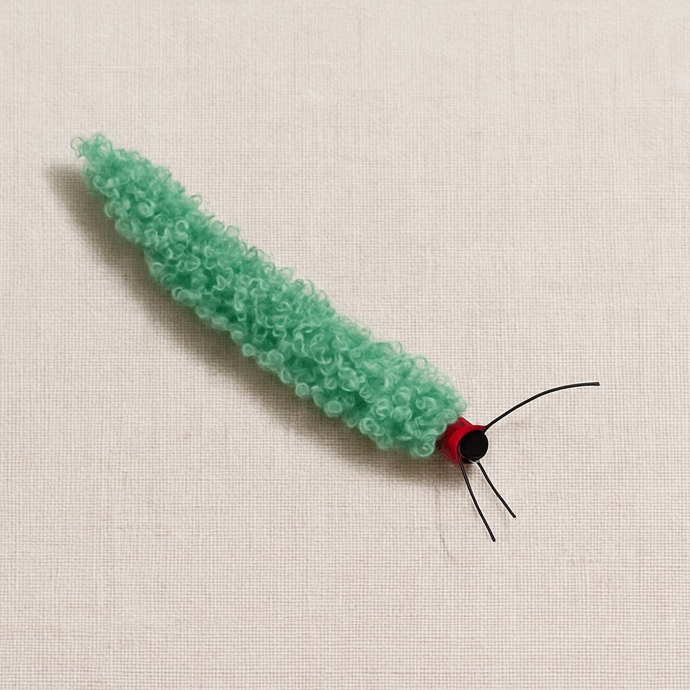Green fuzzy caterpillar cat toy with a red head and antennae