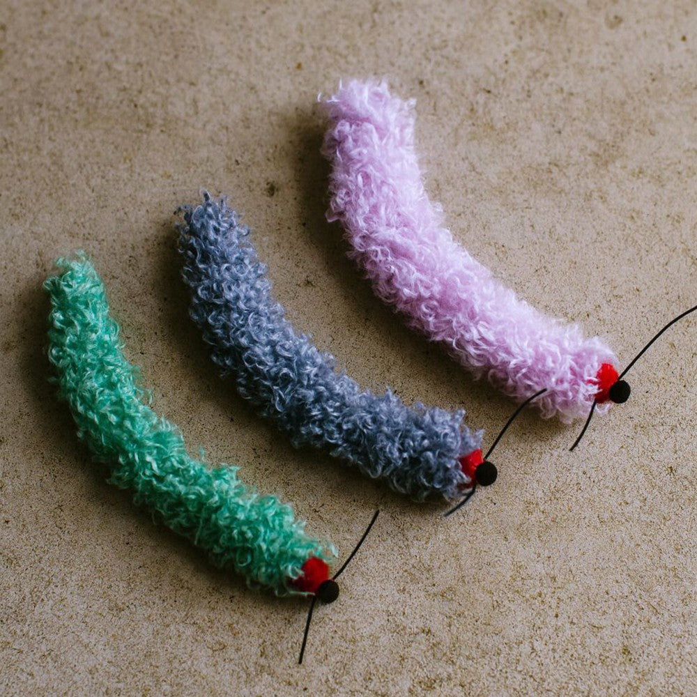 Green, blue-gray and light purple caterpillar toys side by side