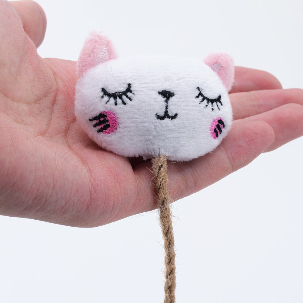 White cat face catnip toy held in a hand