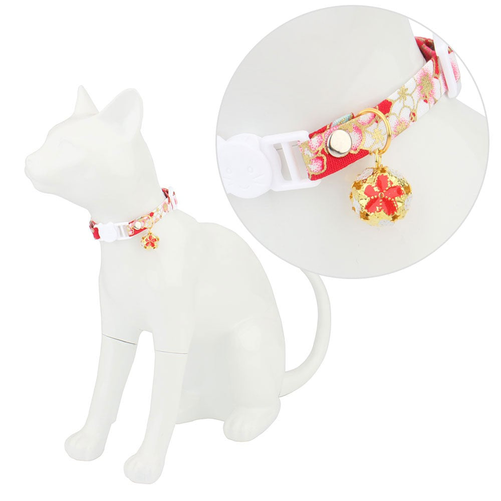 Cherry blossom cat collar on a white cat figure with close-up of the bell