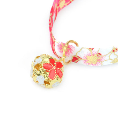 Close-up of the gold bell with pink blossom design
