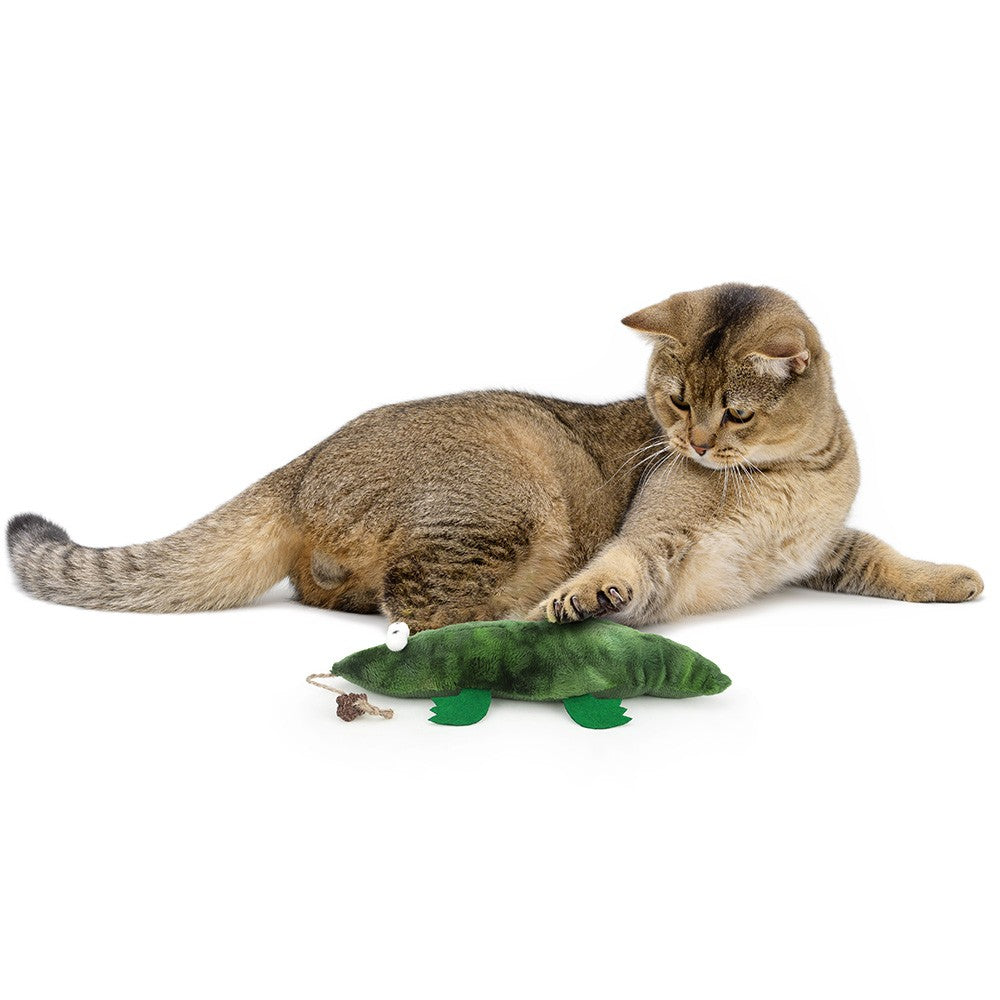 Tabby cat lying with the catnip crocodile toy