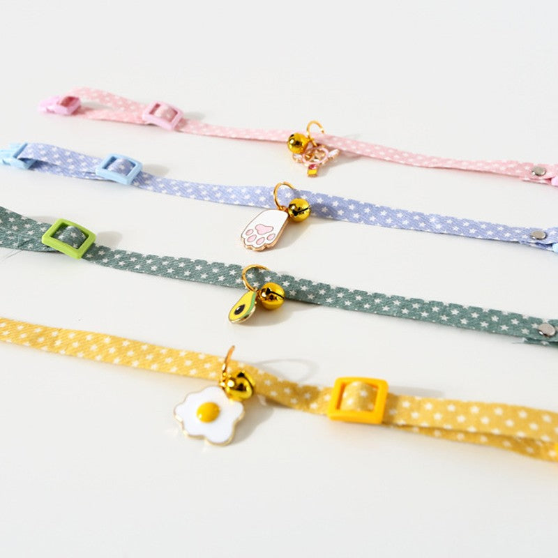 Four cute cat collars with charms laid flat to show the adjustable strap
