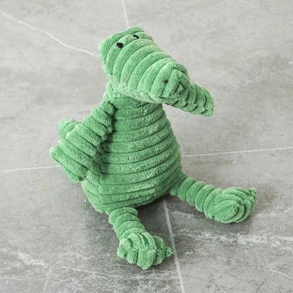 Plush dinosaur dog toy on a grey tiled floor