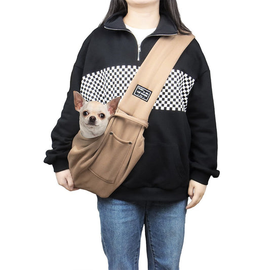Dog carrier bag worn as a shoulder sling with a small dog peeking out