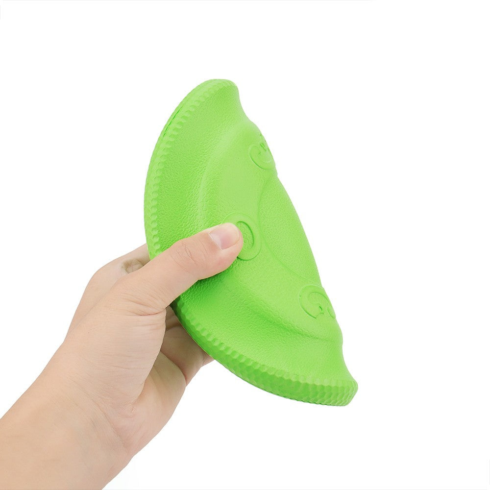Hand bending the soft green foam dog frisbee to show how flexible it is