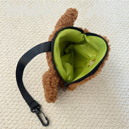 Inside of the plush poop bag holder with a green lining and clip strap