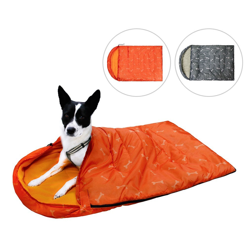 Dog lying in an orange dog sleeping bag with bone print, gray option shown