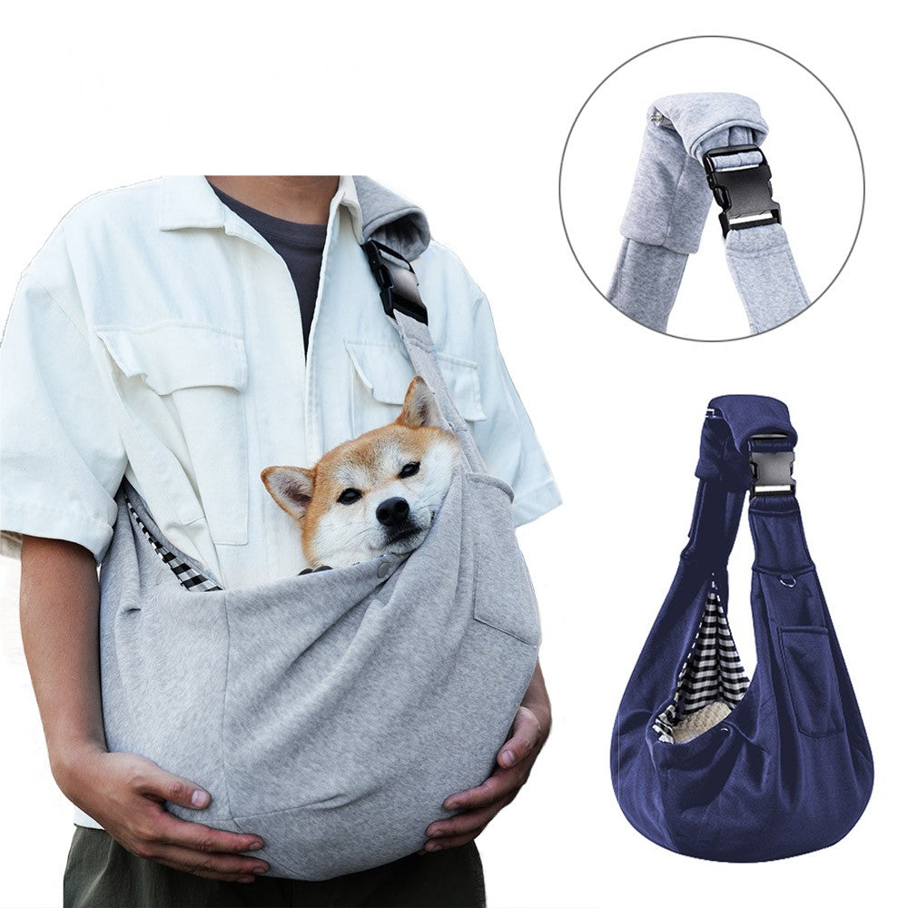 Light gray dog sling carrier worn with a small dog inside
