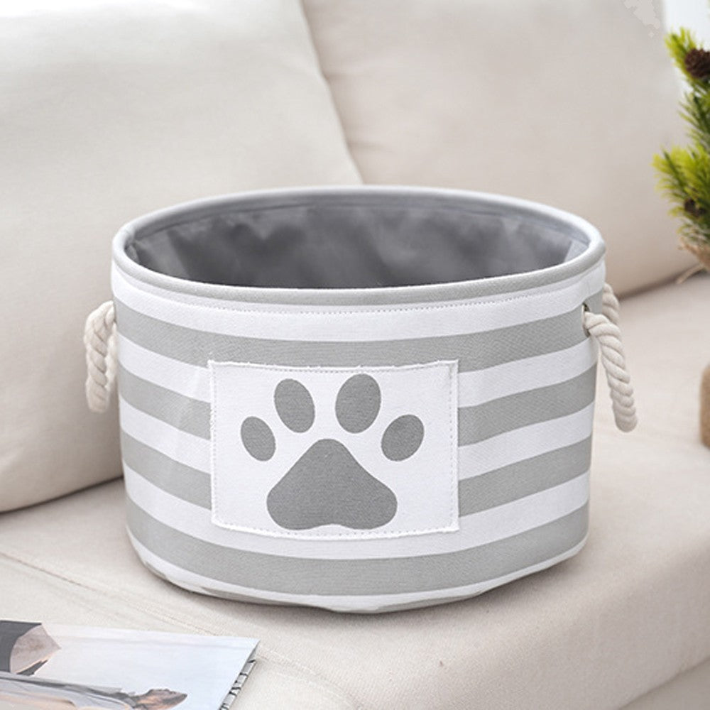 Round striped dog toy basket in gray with a paw print patch