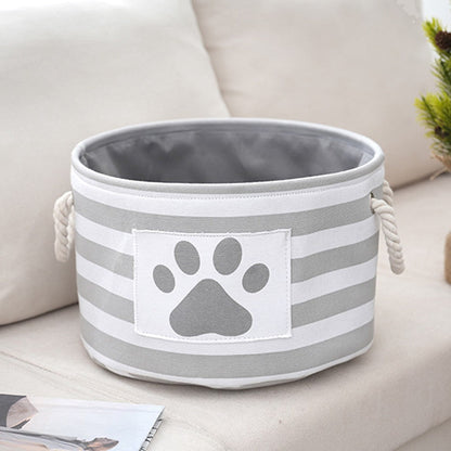 Round striped dog toy basket in gray with a paw print patch