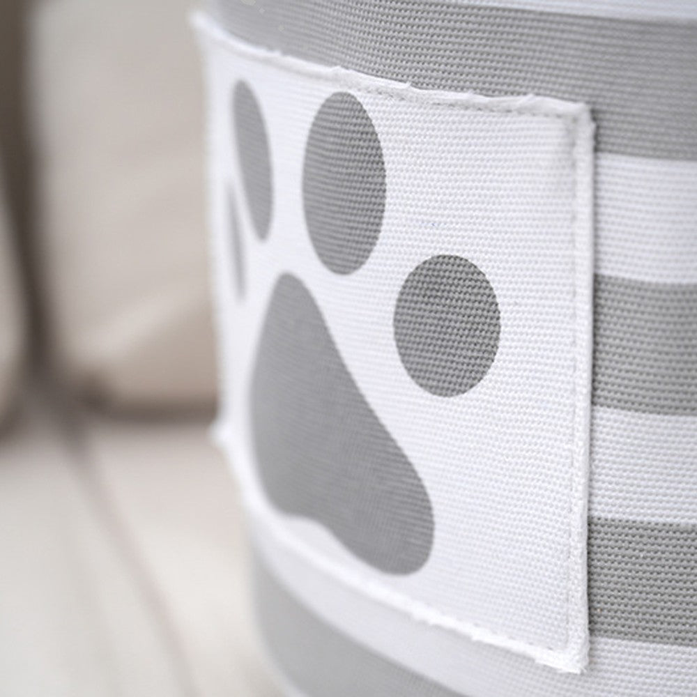 Close-up of the gray paw print patch on the striped toy basket