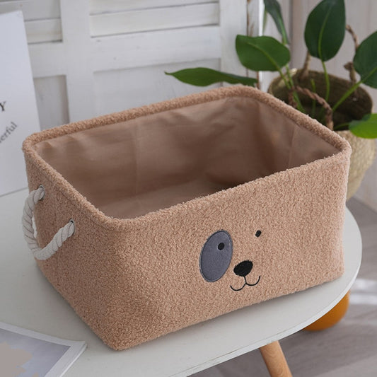 Brown plush dog toy box with a cartoon puppy face and rope handles