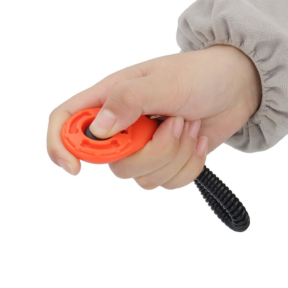Thumb pressing the button on an orange training clicker