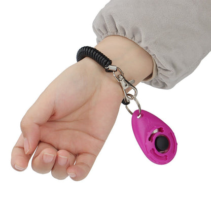 Training clicker hanging from the wrist on its coiled strap