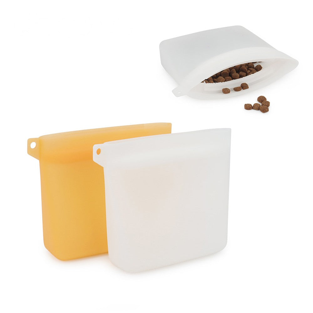 Silicone dog treat bag in white with kibble, next to an orange pouch