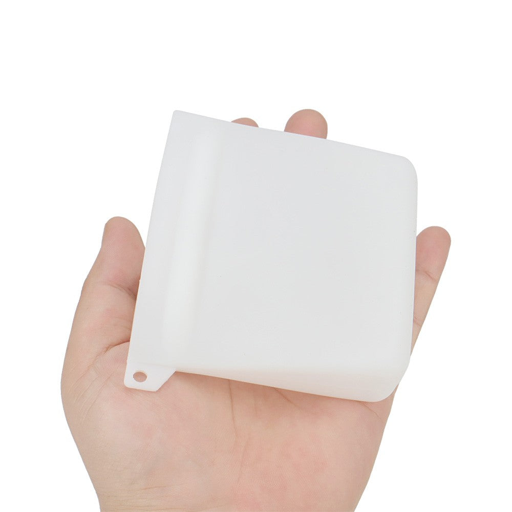 White silicone treat pouch held in one hand to show the size
