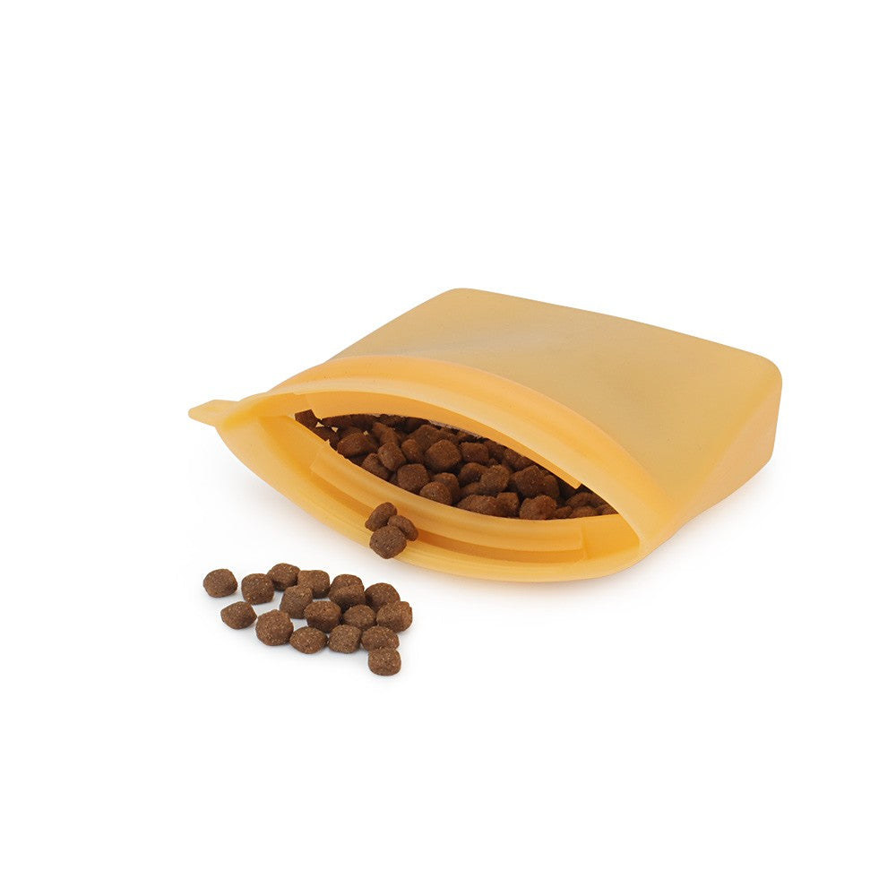 Orange silicone treat pouch open with dog kibble inside