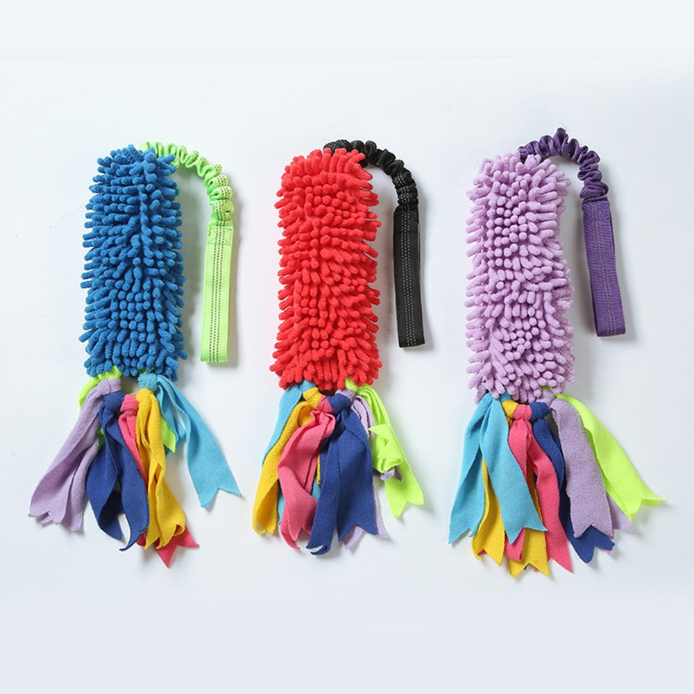 Three dog tug toys in blue, red and purple with shaggy plush heads and fabric tassels