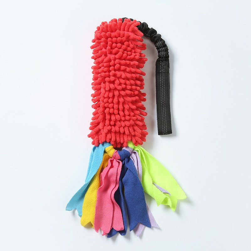 Red dog tug toy with fabric tassels and a black elastic handle
