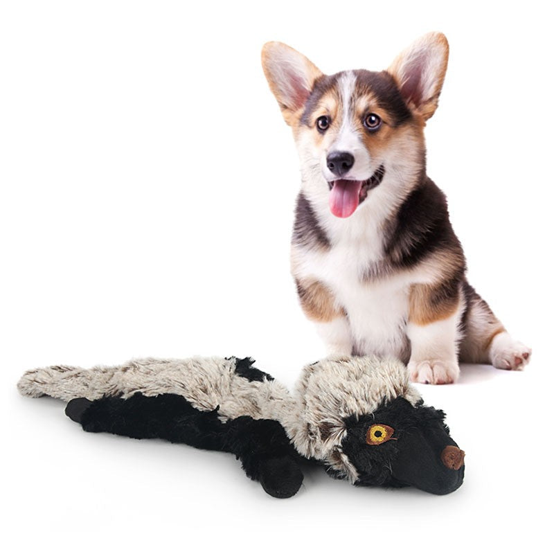 Corgi lying beside the honey badger plush dog toy