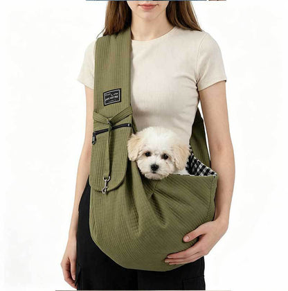 Olive green sling worn on the front with a small dog