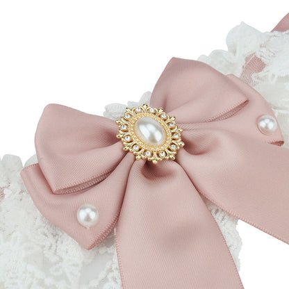 Close-up of the satin bow, faux pearls and gold-tone brooch