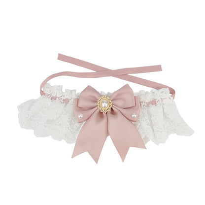 Lace bow cat collar in dusty pink with pearl and gold brooch on white lace
