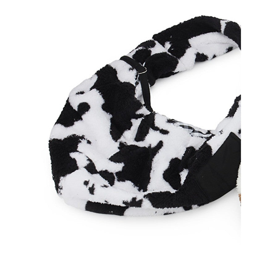 Black and white cow print plush pet carrier bag laid flat