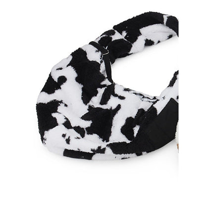 Black and white cow print plush pet carrier bag laid flat