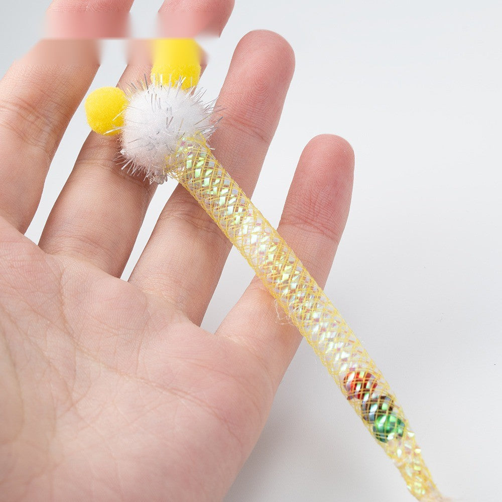 White pom-pom cat toy with a yellow mesh tube, held in a hand