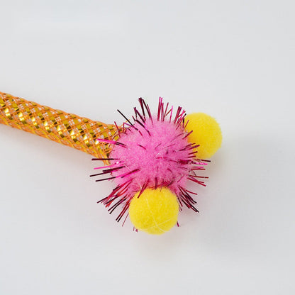 Close-up of a pink glitter pom-pom and orange mesh tube