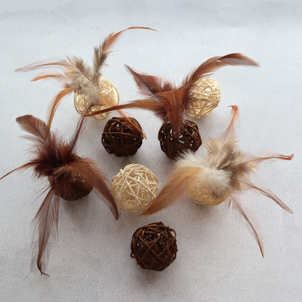 Rattan balls and feathers scattered on a white surface