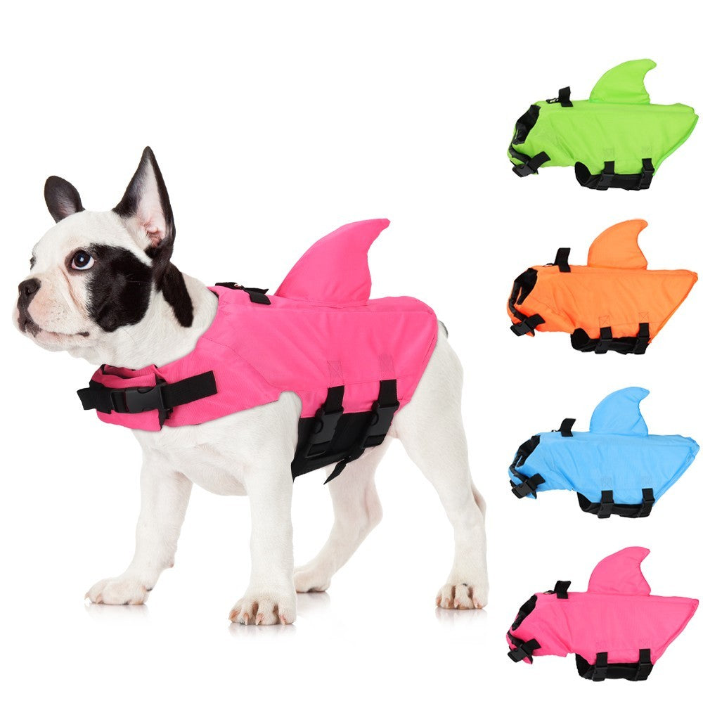 French bulldog wearing a pink shark life vest, with green, orange and blue options