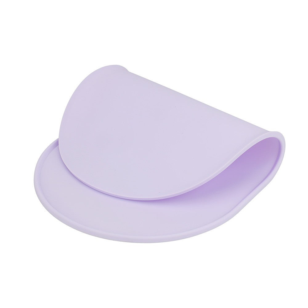 Flexible purple silicone mat curled to show it bends and rolls for storage