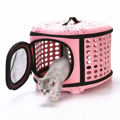 Small dog carrier in pink floral with a kitten stepping out of the mesh door