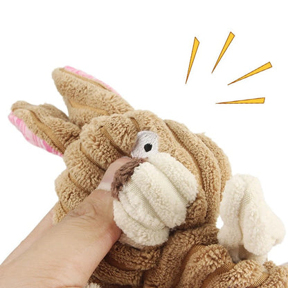 Hand pressing the tan rabbit toy to sound the squeaker