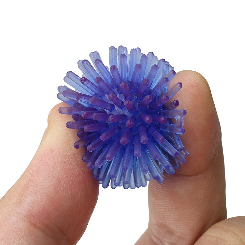Blue spiky ball squeezed between fingers to show it is soft