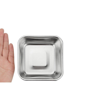 Hand next to the small square stainless steel bowl for scale