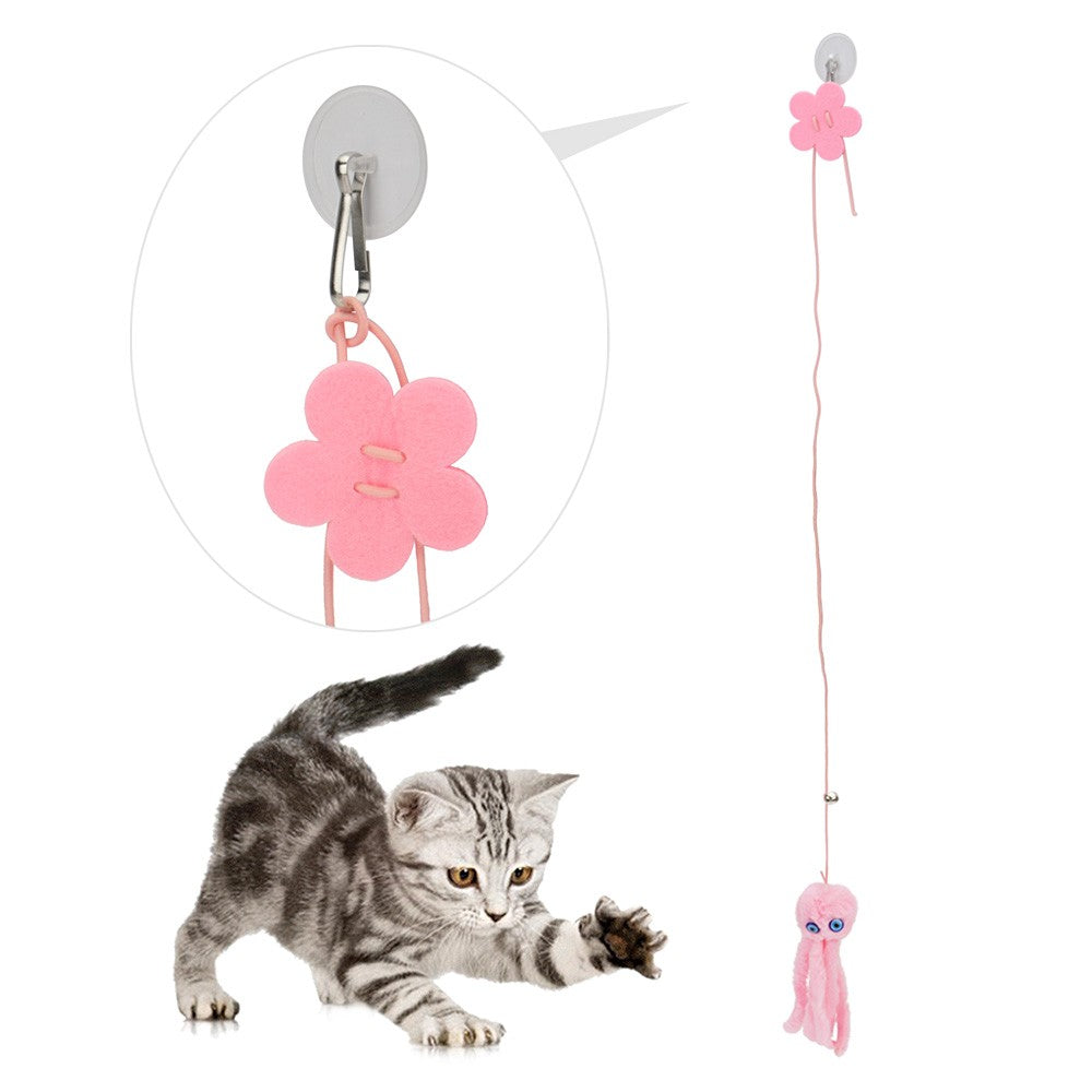 Flower suction cup holding the octopus toy on a door while a kitten plays